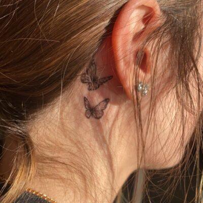 Butterfly tattoo behind ear.